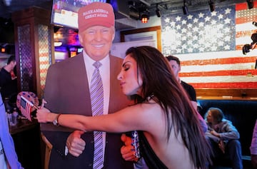 Una partidaria del candidato presidencial republicano, el expresidente estadounidense Donald Trump, abraza una figura de cartón de Trump mientras reacciona a los resultados electorales mientras asiste a la fiesta de observación del New York Young Republican Club durante las elecciones presidenciales estadounidenses de 2024, en Manhattan, Nueva York.