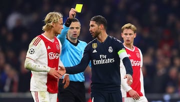 AMSTERDAM, NETHERLANDS - FEBRUARY 13: Referee Damir Skomina shows Sergio Ramos of Real Madrid a yellow card during the UEFA Champions League Round of 16 First Leg match between Ajax and Real Madrid at Johan Cruyff Arena on February 13, 2019 in Amsterdam, 