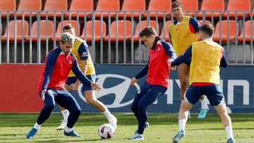 Griezmann y Riquelme, en un ejercicio durante la sesión del Atlético ante el Villarreal. Las dos caras de los banquillos.