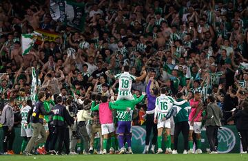 Los jugadores y aficionados del Betis, celebran la victoria ante el Sevilla tras finalizar el partido en el estadio Benito Villamarn.