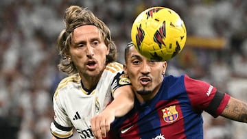 Barcelona's Brazilian forward #11 Raphinha vies with Real Madrid's Croatian midfielder #10 Luka Modric during the Spanish league football match between Real Madrid CF and FC Barcelona at the Santiago Bernabeu stadium in Madrid on April 21, 2024. (Photo by JAVIER SORIANO / AFP)