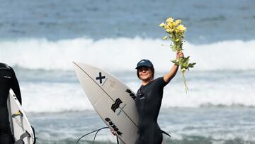 Daniela Boldini con unas flores antes de entrar al agua en el Spring Surfest Las Américas Pro 2024, en Arona (Tenerife).