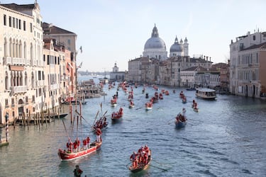 Personas vestidas de Papá Noel reman durantela  regata navideña en el Gran Canal de Venecia.