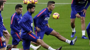 Rodrigo estirando en la sesión del Atlético ayer, junto a Correa y Costa, en el Metropolitano.