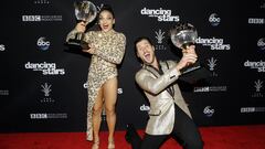 Valentin Chmerkovskiy (agachado) y la gimnasta Laurie Hernandez, con sus trofeos Mirror Ball.