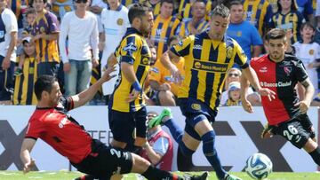 Pugna por el balón en un clásico entre Newells y Rosario Central.