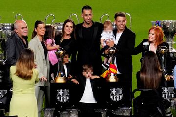 Busquets posa con su familia ante sus títulos con el Barcelona.