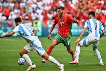 Morocco's midfielder #17 Oussama El Azzouzi (C) passes the ball past Argentina's defender #03 Julio Soler (L) and Argentina's midfielder #07 Kevin Zenon in the men's group B football match between Argentina and Morocco during the Paris 2024 Olympic Games at the Geoffroy-Guichard Stadium in Saint-Etienne on July 24, 2024. (Photo by Arnaud FINISTRE / AFP)