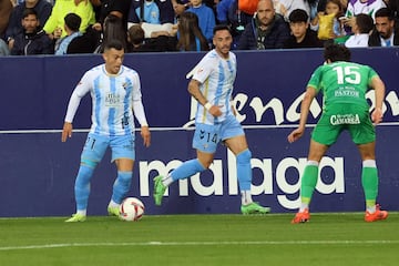 Manu Molina conduce el balón. A su lado Víctor García.