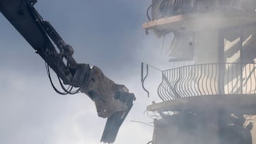 The arm of an earth mover is seen as emergency crews continue search and rescue operations for survivors of a partially collapsed residential building in Surfside, near Miami Beach, Florida, U.S. June 25, 2021.  REUTERS/Octavio Jones     TPX IMAGES OF THE