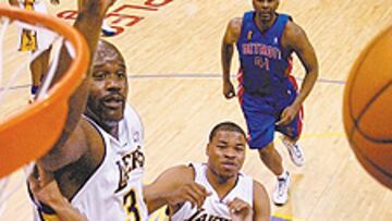 <b>FINGER ROLL.</b> El piston Tayshaun Prince gira los dedos y anota ante Shaq. Atrás, George y E. Campbell.