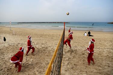 Un grupo de personas vestidas todas de Papá Noel disputa un partido de voley playa en Tel Aviv, dentro del programa de actividades navideñas promovidas por el Ayuntamiento de la ciudad israelí. Una imagen muy distinta a la de los paisajes nórdicos en los que solemos ver a Papá Noel.