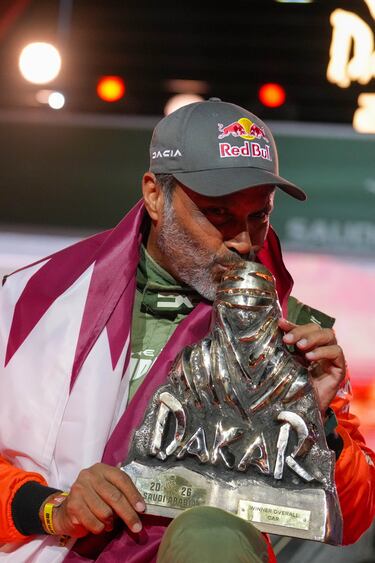 El piloto Nasser Al-Attiyah besa su trofeo mientras celebra su victoria. 