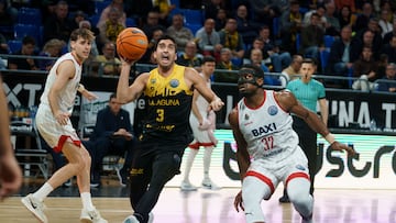 El escolta de La Laguna Tenerife Jaime Fernández (i) entra a canasta ante el base del Baxi Manresa Retin Obasohan (d), durante el sexto partido del Top 16 de la Liga de Campeones de baloncesto que se disputó este martes en el pabellón Santiago Martín de La Laguna (Tenerife).