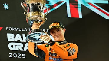 McLaren's Australian driver Oscar Piastri lifts the throphy on podium after winning the Bahrain Formula One Grand Prix at the Bahrain International Circuit in Sakhir on April 13, 2025. (Photo by Giuseppe CACACE / AFP)