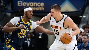 Denver Nuggets center Nikola Jokic (15) dribbles the ball while Indiana Pacers center Myles Turner (33) defends in the first half at Gainbridge Fieldhouse.