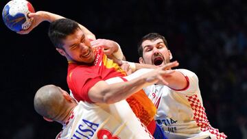 Alex Dujsebaev intenta lanzar con Musa y Gojun colgados de él.