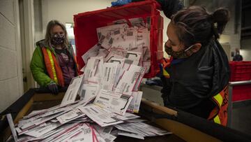 La trabajadora electoral Kristen Mun de Portland vacía las papeletas de una urna en la División de Elecciones del Condado de Multnomah, el martes 3 de noviembre de 3030 en Portland, Oregon.
