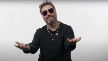 El skater Bam Margera en un fondo blanco, vestido de negro, levantando las manos, para repasar sus peores caídas de su carrera en el skate en Battle Scars de The Berrics.