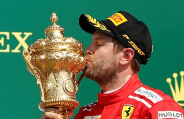 Sebastian Vettel celebrando la victoria con su trofeo en el pódium.