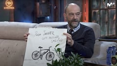 El humorista Javier Cansado, sentado en el sof&aacute; de La Resistencia, en Movistar +, mirando a David Broncano y ense&ntilde;ando un dibujo de una bicicleta el&eacute;ctrica hecho por Jorge Ponce. 