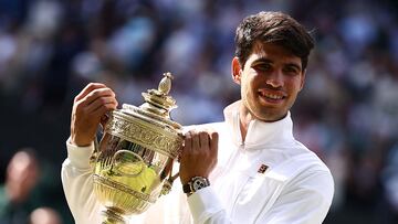 Spain's Carlos Alcaraz poses with the winner's trophy after beating Serbia's Novak Djokovic during their men's singles final tennis match on the fourteenth day of the 2024 Wimbledon Championships at The All England Lawn Tennis and Croquet Club in Wimbledon, southwest London, on July 14, 2024. Defending champion Alcaraz beat seven-time winner Novak Djokovic in a blockbuster final, with Alcaraz winning 6-2, 6-2, 7-6. (Photo by HENRY NICHOLLS / AFP) / RESTRICTED TO EDITORIAL USE