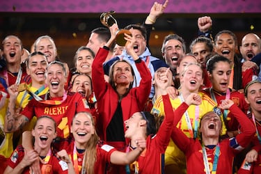 La reina Letizia levanta la Copa del Mundo en el podio junto a las jugadoras de España. 
 