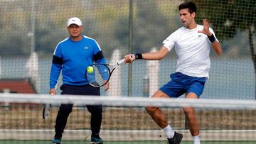 El tenista serbio Novak Djokovic entrena bajo la supervisión de su entrenador Marian Vajda durante un entrenamiento en 2018.