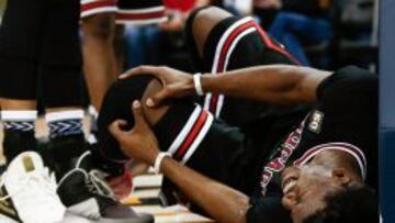 Jimmy Butler se toca la rodilla lesionada.