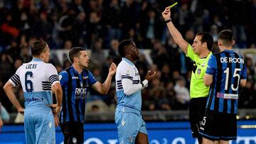 El arbitro, Luca Banti, señala la primera tarjeta amarilla al defensa angoleño Bastos.