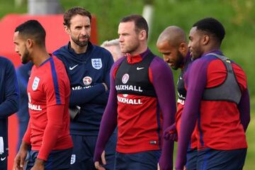 England interim manager Gareth Southgate (2L) leads a training session by Theo Walcott (L), Wayne Rooney and Danny Rose at St George's Park in Burton-on-Tren