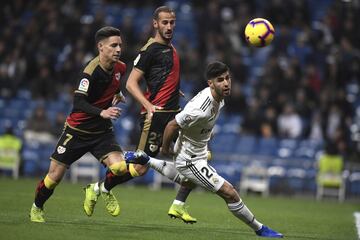 El jugador del Real Madrid Asensio trata de controlar el balón ante el jugador del Rayo Vallecano Moreno. 
