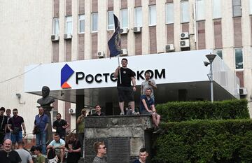 Un partidario del grupo de mercenarios privados de Wagner sostiene una bandera frente a una oficina de Rostelecom cerca de la sede del Distrito Militar del Sur controlado por soldados de Wagner en la ciudad de Rostov.