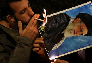 A demonstrator lights a cigarette with fire from a burning picture of Iran's Supreme Leader Ayatollah Ali Khamenei outside the Iranian embassy during a rally in support of nationwide protests in Iran, in London, Britain, January 12, 2026. REUTERS/Toby Melville TPX IMAGES OF THE DAY