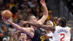 Nikola Jokic #15 of the Denver Nuggets is guarded by Terance Mann #14 and Kawhi Leonard #2 of the Los Angeles Clippers in the third quarter at Ball Arena on November 14, 2023 in Denver, Colorado.