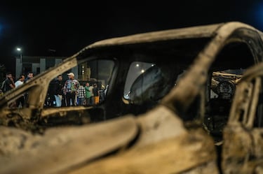 Personas junto a un vehículo policial incendiado mientras las protestas lideradas por jóvenes que exigían reformas sanitarias y educativas se tornaron violentas en Salé, Marruecos.