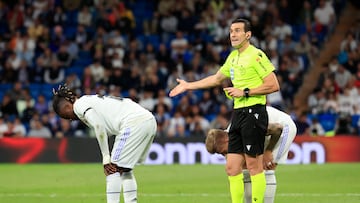 MADRID 13/05/2023.- El centrocampista francés del Real Madrid, Eduardo Camavinga (i) se duele delante del colegiado Martínez Munuera (c) durante el partido correspondiente a la jornada 34 de LaLiga Santander que enfrenta al Real Madrid y Getafe SAD este sábado en el Santiago Bernabéu. EFE/ Zipi Aragon
