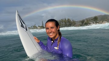 Moana Jones en el agua con el arcoíris de fondo