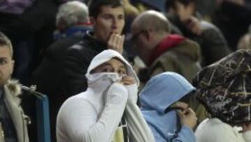 Los aficionados tratan de cubrirse la cara para protegerse de los efectos del gas lacrimógeno.