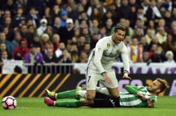 Real Madrid's Portuguese forward Cristiano Ronaldo is tackled by Betis' Argentinian defender German Pezzela (R) during the Spanish league footbal match Real Madrid CF vs Real Betis at the Santiago Bernabeu stadium in Madrid on March 12, 2017. / AFP PHOTO 