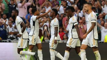 Real Madrid's English midfielder #5 Jude Bellingham celebrates with teammates after scoring his team's first goal during the Spanish league football match between Real Madrid CF and CA Osasuna at the Santiago Bernabeu stadium in Madrid on October 7, 2023. (Photo by Pierre-Philippe MARCOU / AFP)