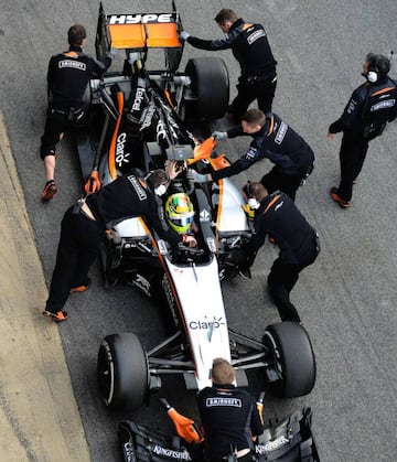 Mechanics work on the car of Sahara Force India F1 Team's Mexican driver Sergio Perez in the pit at the Circuit de Catalunya.