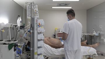 Un sanitario alrededor de un paciente ingresado en un hospital