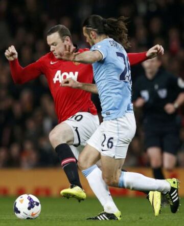 Demichelis intenta parar a Wayne Rooney.