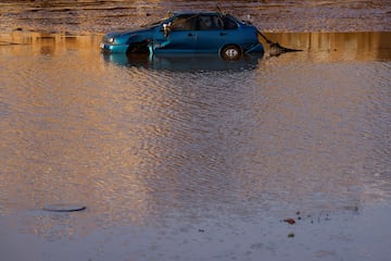 Un coche se encuentra parcialmente sumergido tras las inundaciones en Utiel, España.