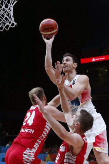 El ala-pívot español Víctor Claver (c) y el pívot polaco Przemyslaw Karnowski (i) durante el partido de octavos de final del Europeo 2015 entre las selecciones de España y Polonia, celebrado en el estadio Pierre Mauroy de la localidad francesa de Lille.