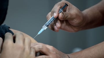 A health worker inoculates a youth with a Covid-19 coronavirus vaccine during a vaccination drive for people in the 15-18 age group, in Mumbai on January 31, 2022. (Photo by INDRANIL MUKHERJEE / AFP)