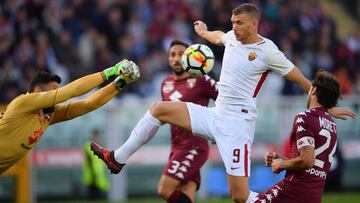 AS Roma's forward Edin Dzeko from Bosnia-Herzegovina (C) fights for the ball with Torino's goalkeeper Salvatore Sirigu (L) during the Italian Serie A football match Torino Vs Roma on October 22, 2017 at the Grande Torino stadium in Turin. / AFP