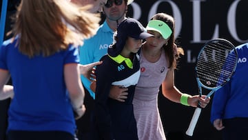 Zeynep Sonmez, con una recogepelotas que sufrió un golpe de calor en el Open de Australia.