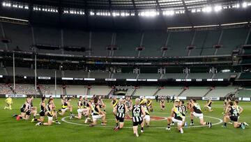 Los jugadores del Collingwood Magpies y del Richmond Tigers, de la Liga de Fútbol Australiano (AFL), se arrodillan sobre el césped del estadio multiusos Melbourne Crikect Ground, antes de la celebración de un partido, como medida de apoyo al movimiento Black Lives Matter (Las Vidas Negras Importan) en Melbourne, Australia.